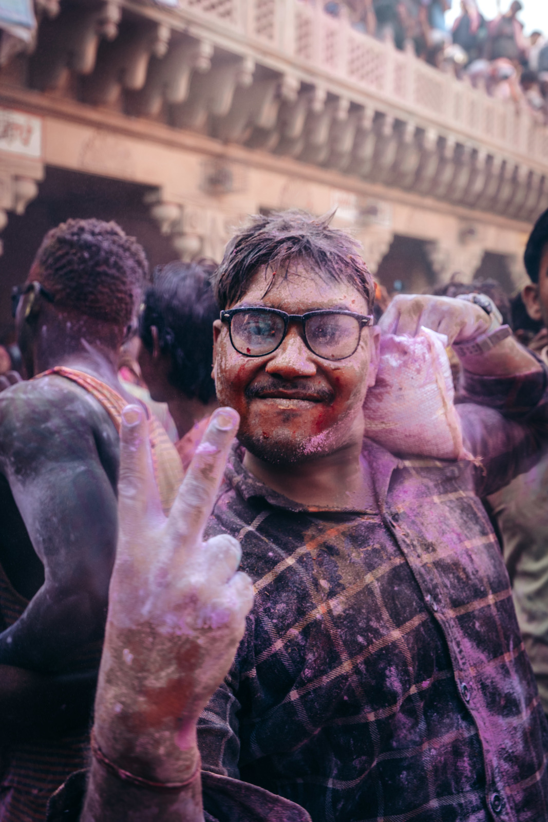 a man is covered in colored powder and giving the peace sign