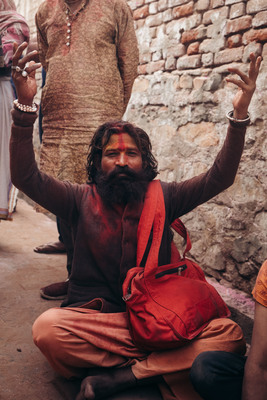 a man sitting on the ground with his hands in the air