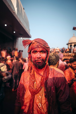 a man in a red turban standing in front of a crowd of people