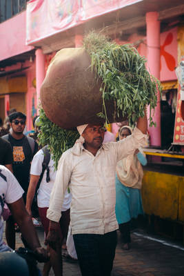 a man carrying a large pot on his head