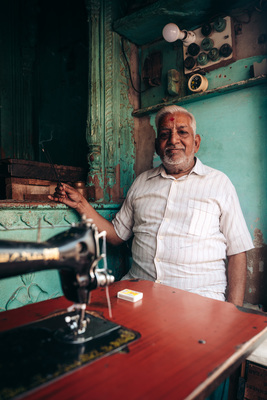 a man standing next to a sewing machine