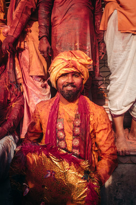 a man in a yellow turban sitting in front of a group of men