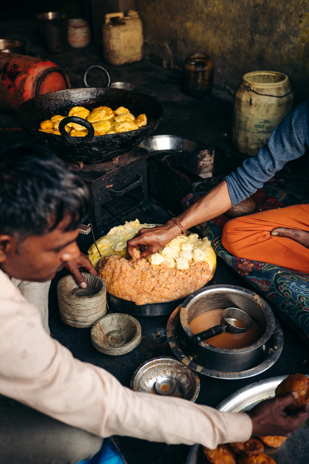 a group of people sitting around a table filled with food