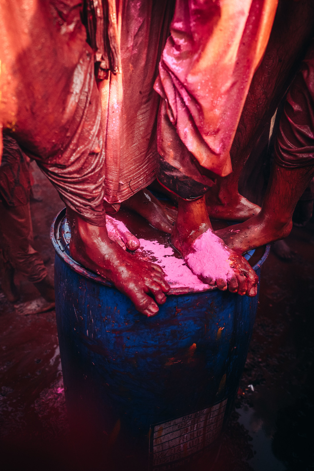 a person standing on top of a blue barrel