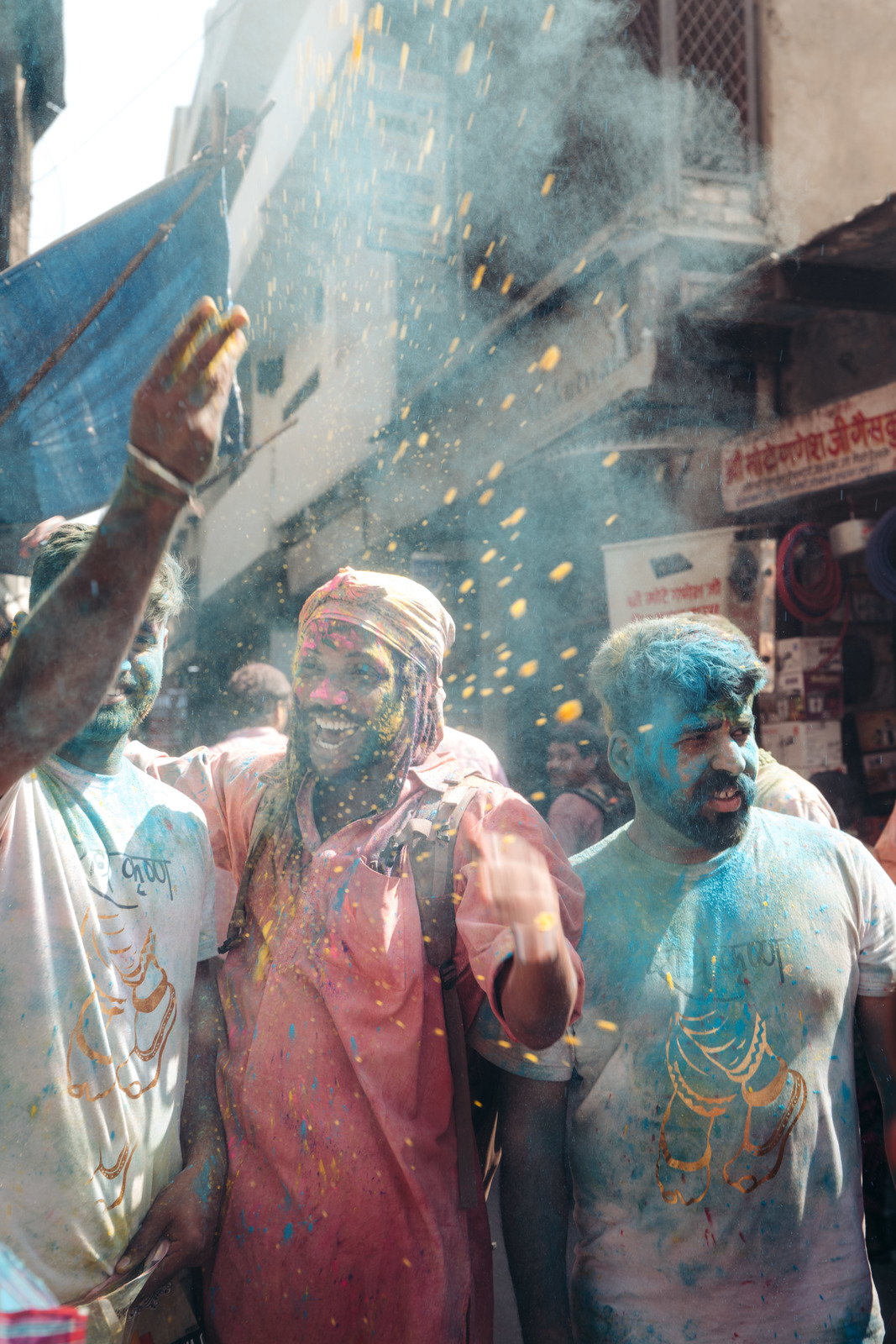 a group of men standing around each other covered in colored powder