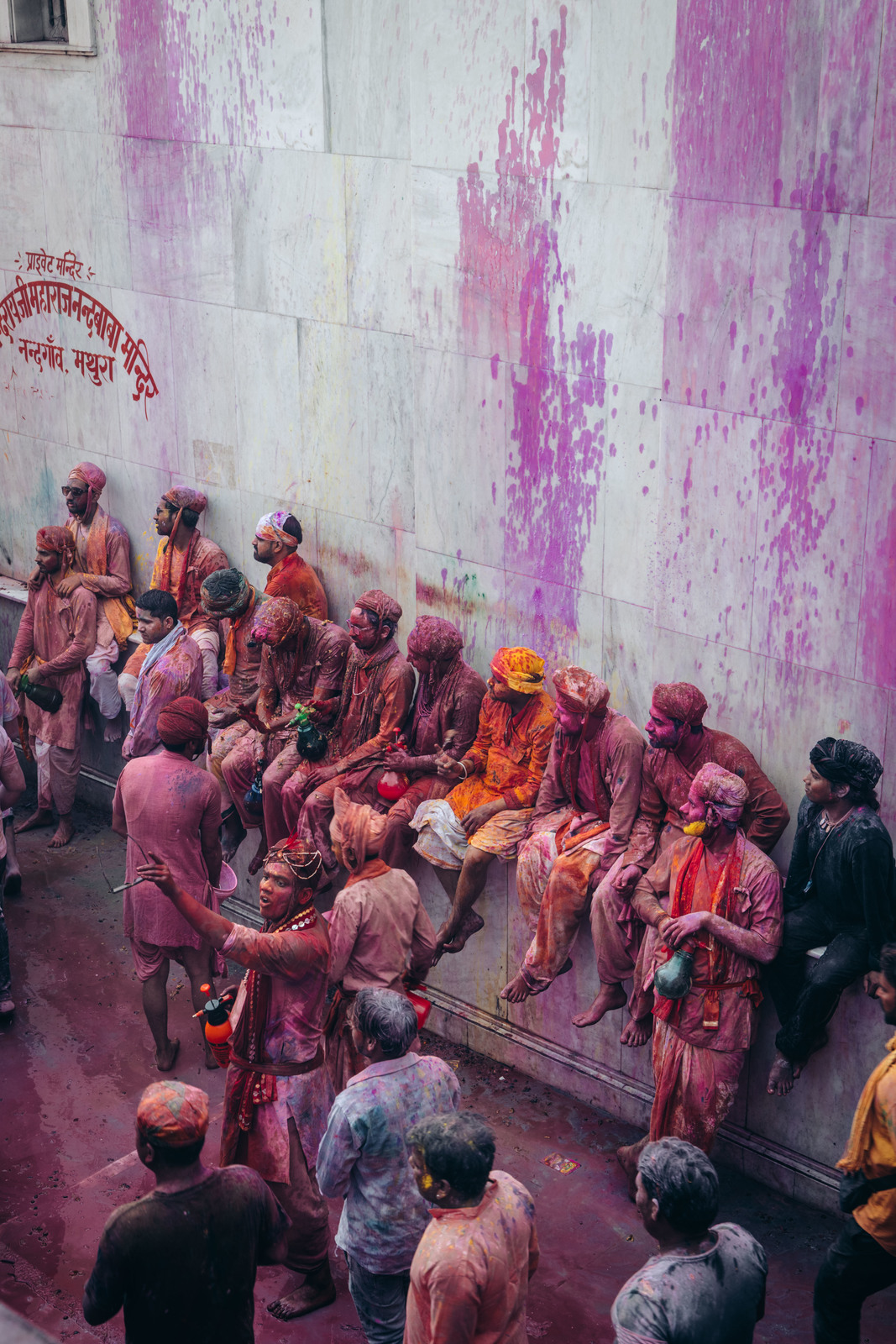 a group of people standing around in front of a wall