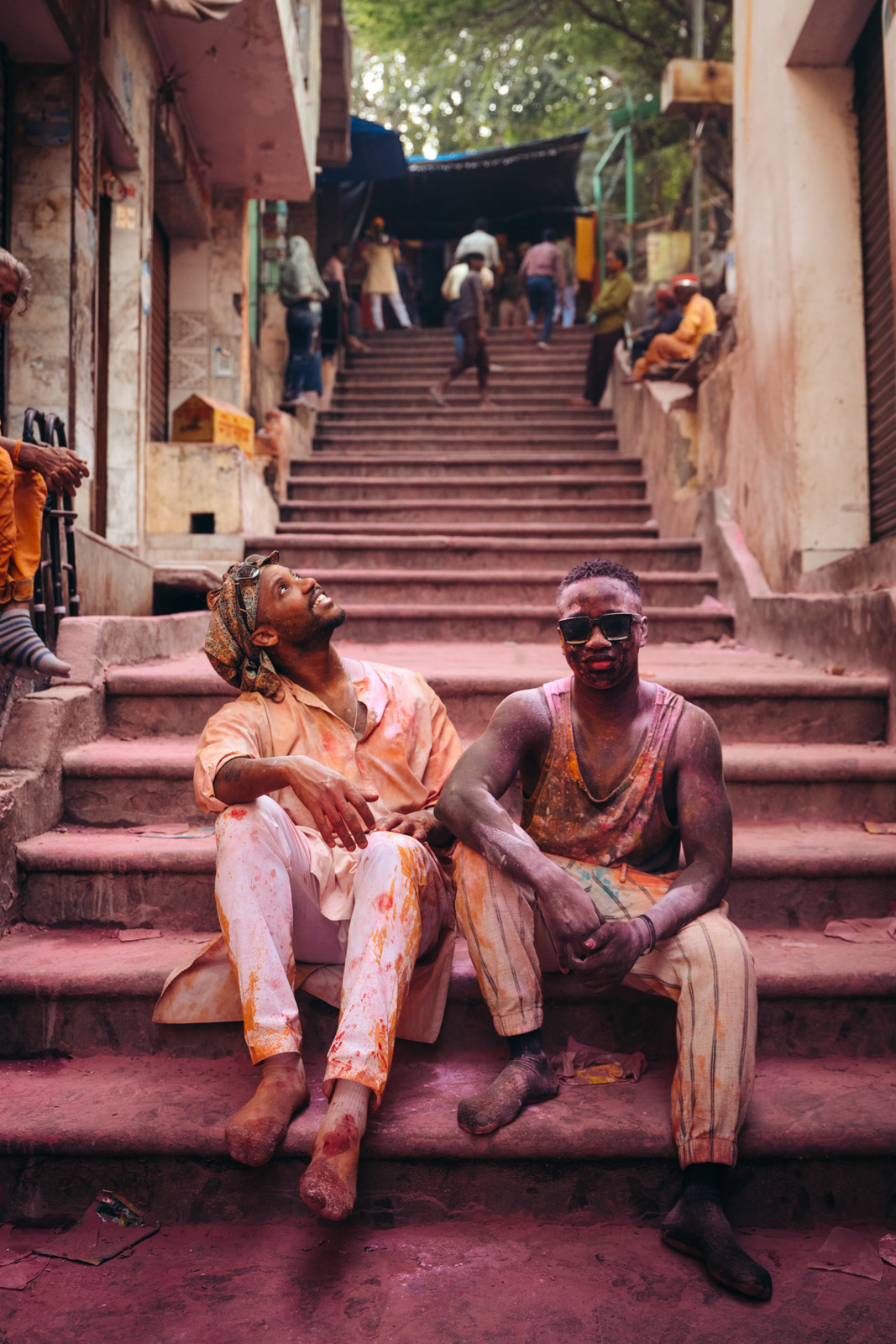 a couple of men sitting on top of a set of stairs