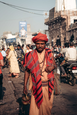 a man walking down a street with a basket in his hand