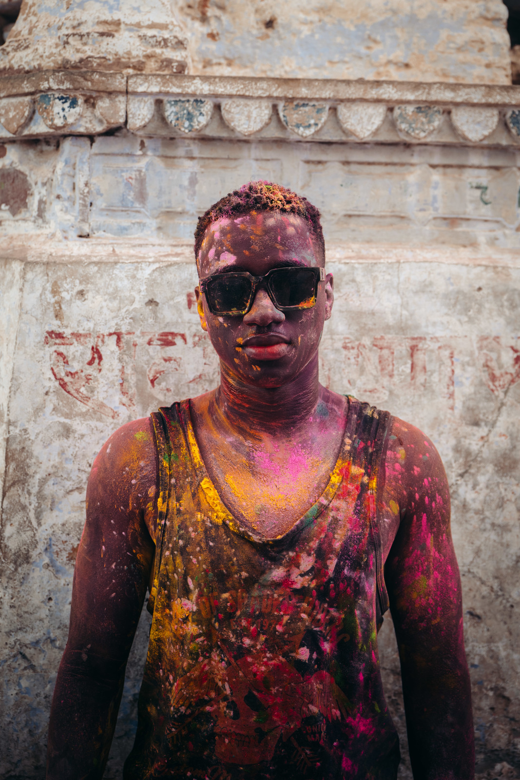 a man covered in colored powder and wearing sunglasses