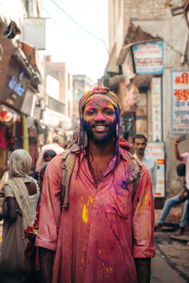 a man in a red shirt and yellow and blue paint on his face