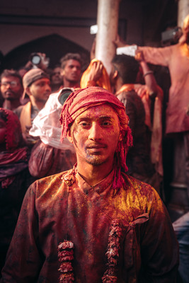 a man in a red turban standing in front of a group of people