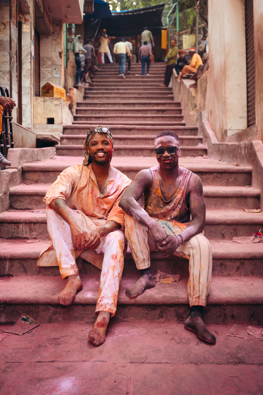 a couple of men sitting on top of a set of stairs