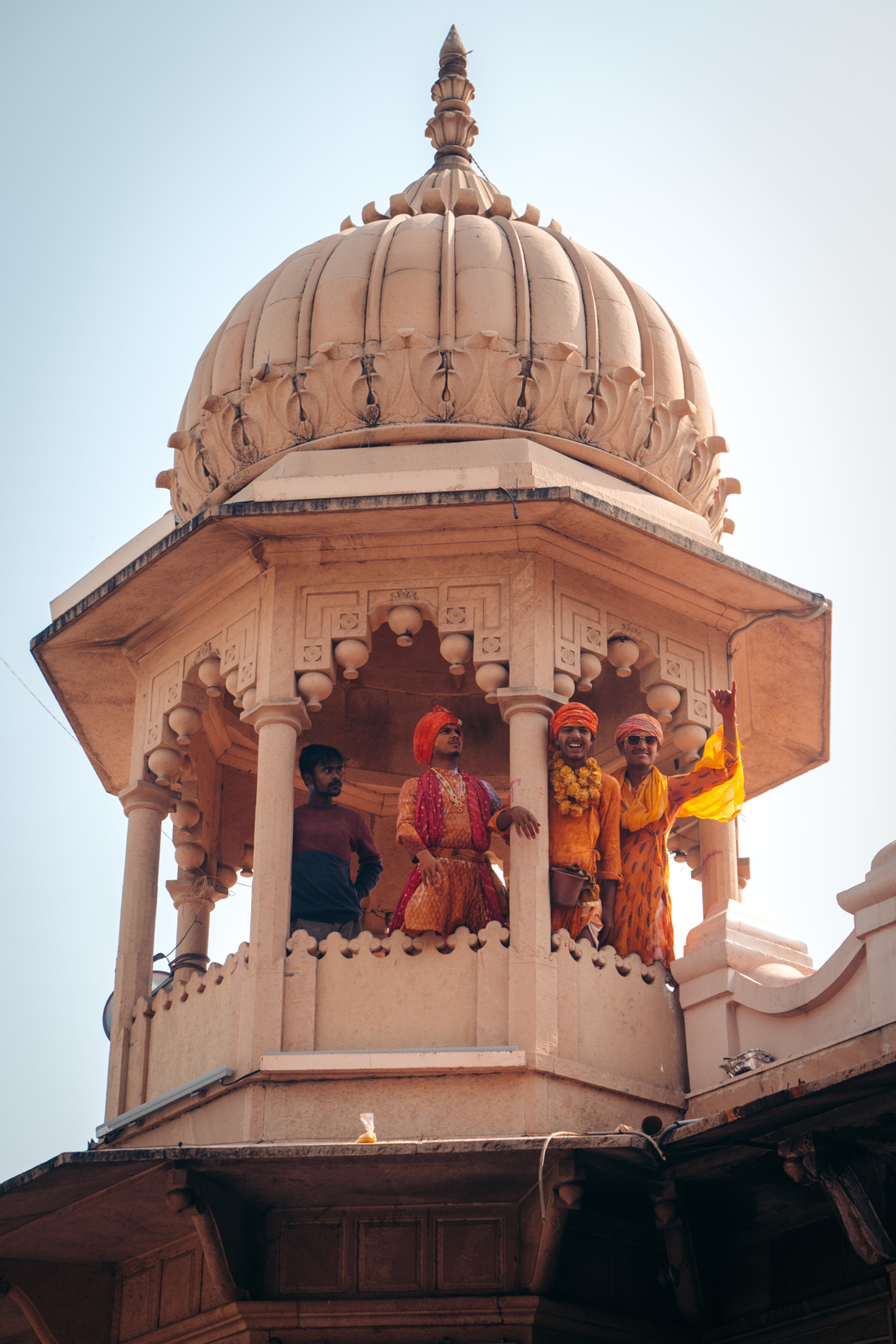 a group of men standing on top of a white building