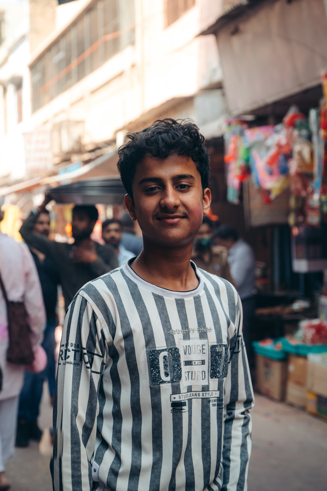 a man in striped shirt standing in front of a crowd of people