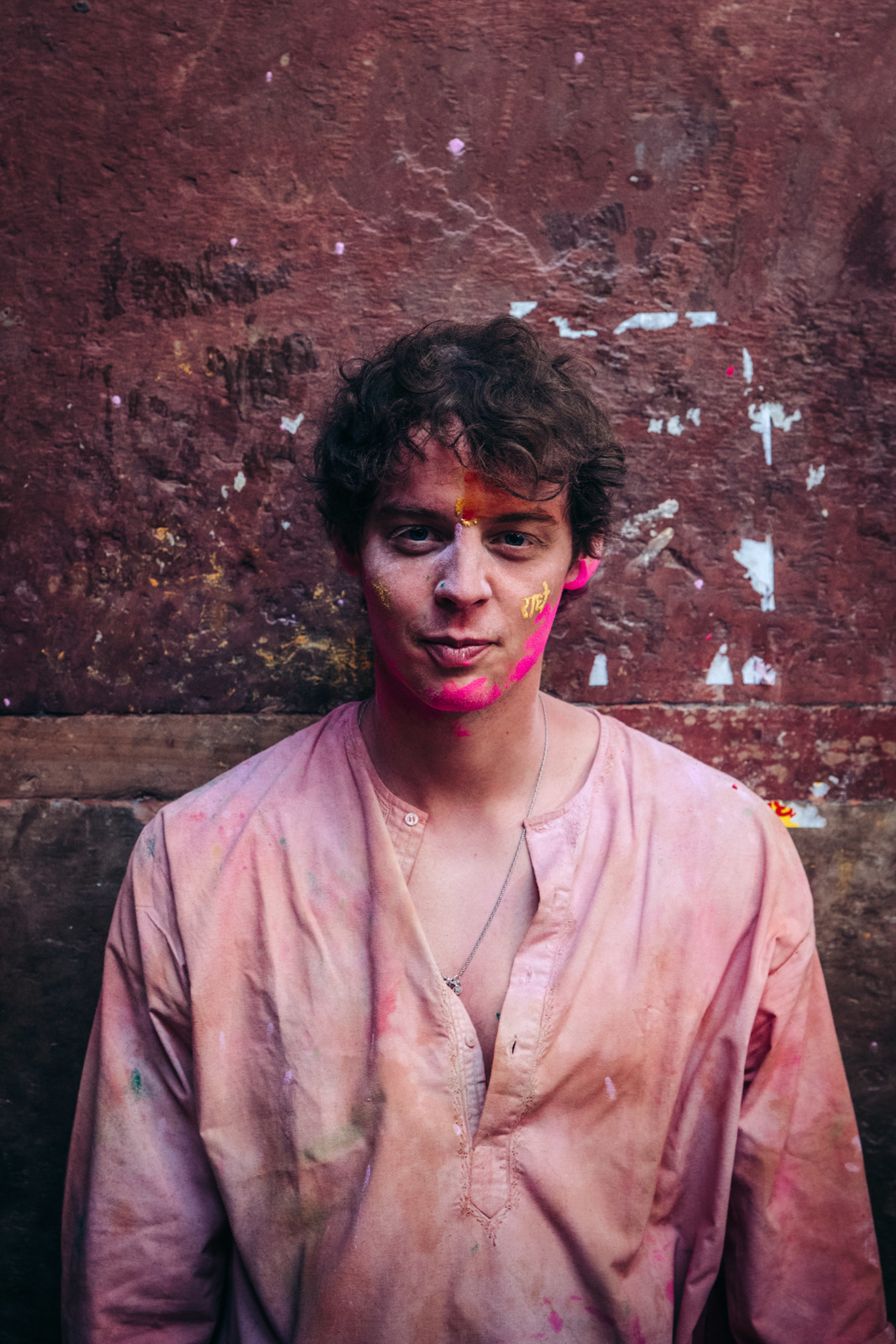 a man standing in front of a dirty wall