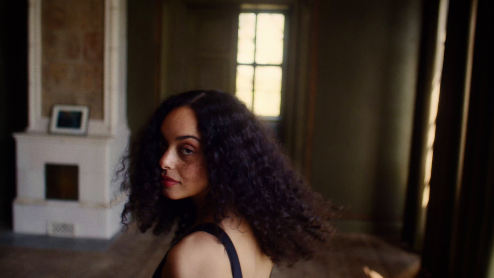 a woman in a black dress standing in a room