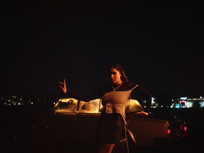 a woman standing next to a boat at night