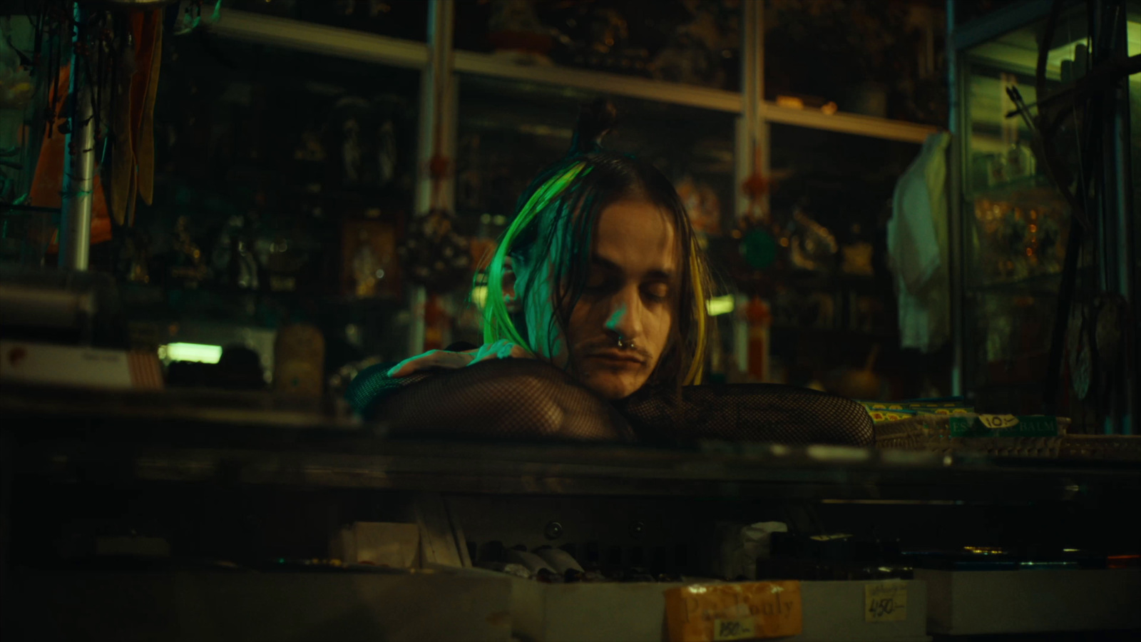 a man with green hair sitting in a room