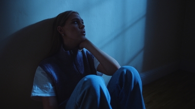 a woman sitting on the floor in a dark room