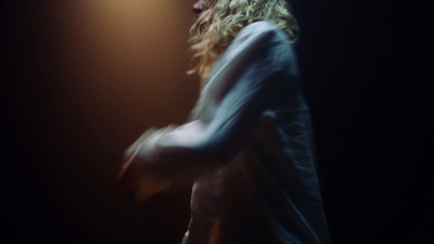 a man standing in front of a microphone in a dark room