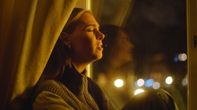 a woman looking out of a window at night