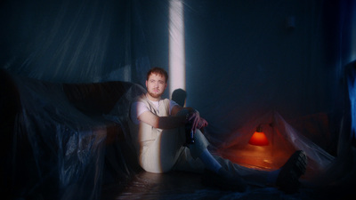 a man sitting on a bed in a dark room