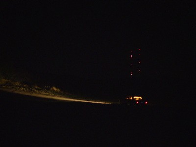 a truck driving down a dark road at night