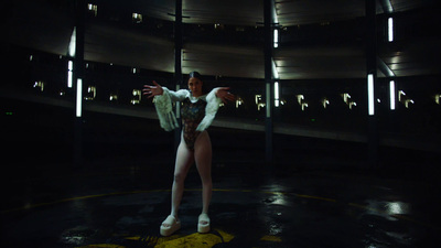 a woman in a white and black outfit standing in a dark room