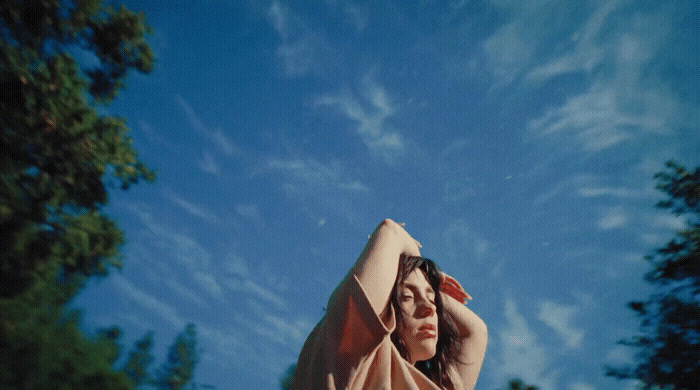 a woman with her arms behind her head