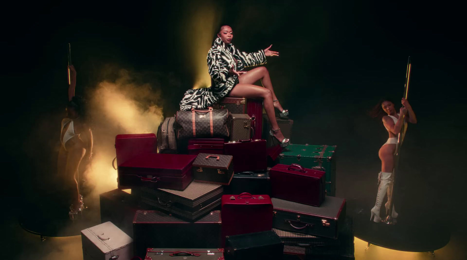 a woman sitting on top of a pile of luggage