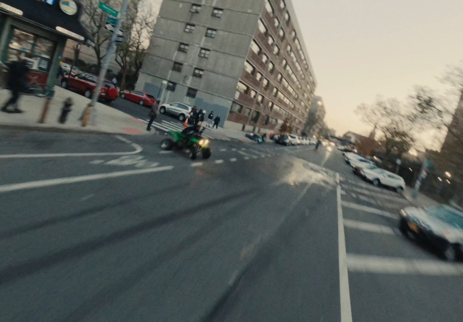 a motorcycle driving down a street next to tall buildings