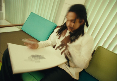 a woman sitting at a table writing on a piece of paper