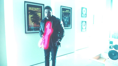 a man standing in front of a wall with posters on it