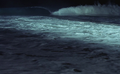 a large wave crashing into the shore of the ocean