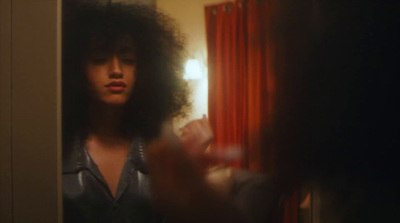 a woman with long hair standing in front of a mirror