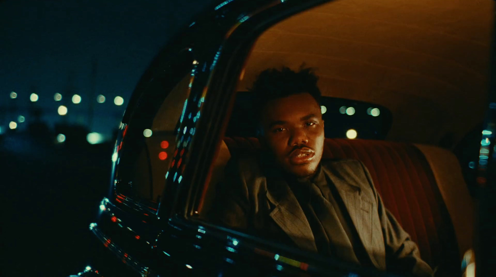 a man sitting in the back of a car at night