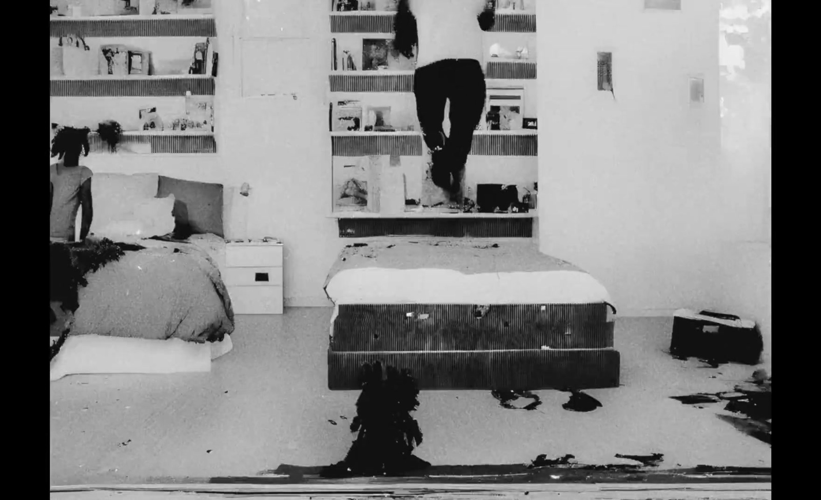 a black and white photo of a person standing on a bed