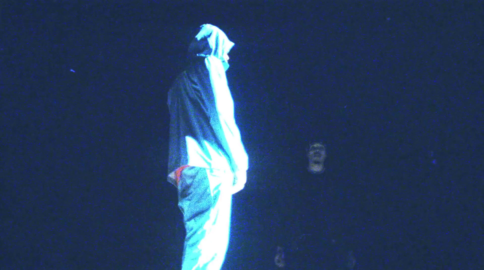 a person standing on a skateboard in the dark