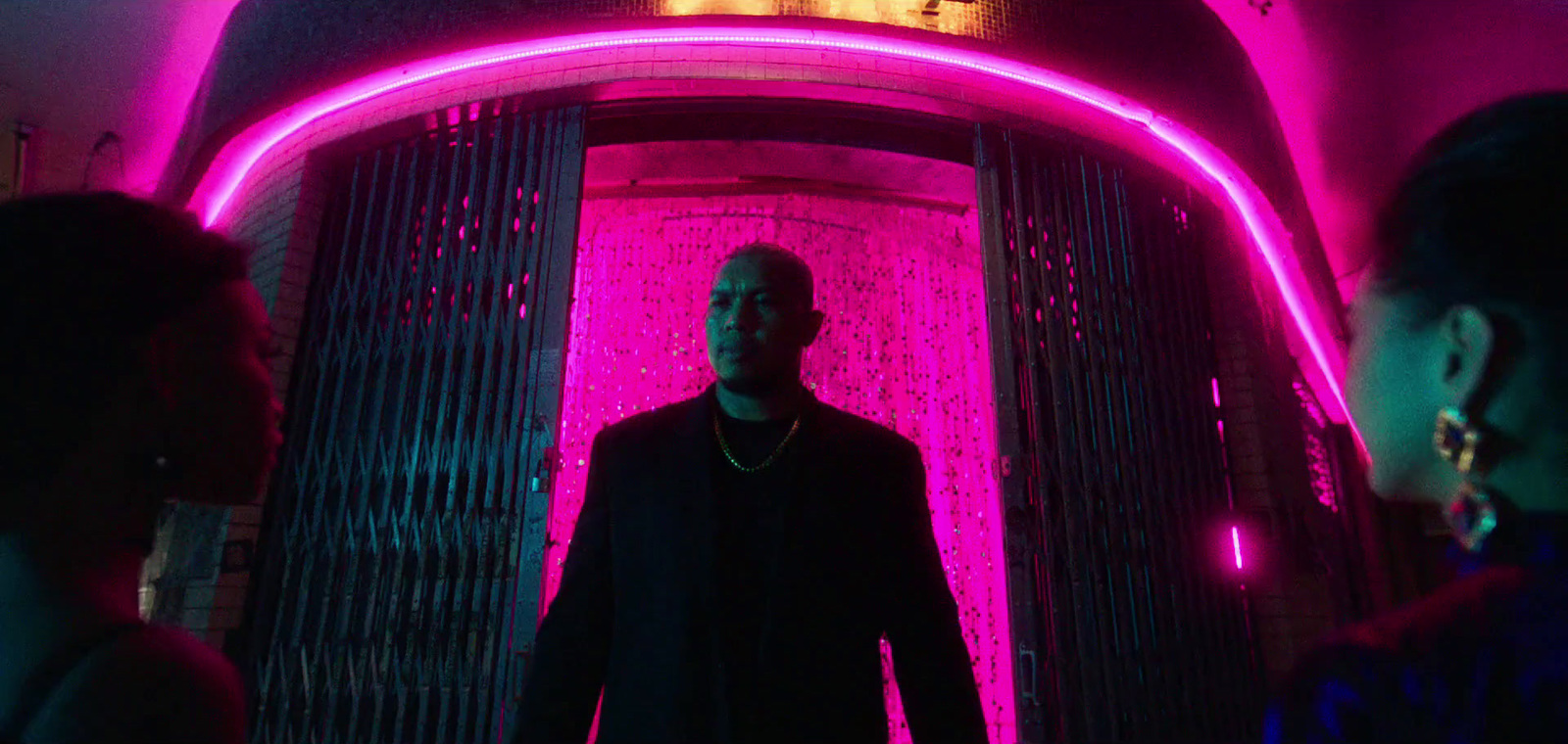 a man standing in front of a neon sign