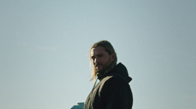 a man with long hair and a beard holding a frisbee