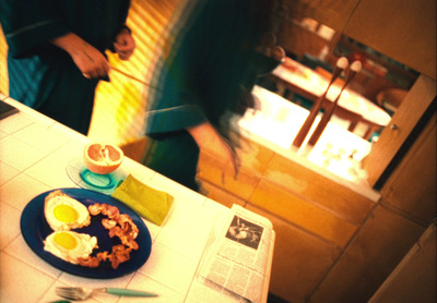 a blue plate topped with eggs and bacon next to a knife and fork