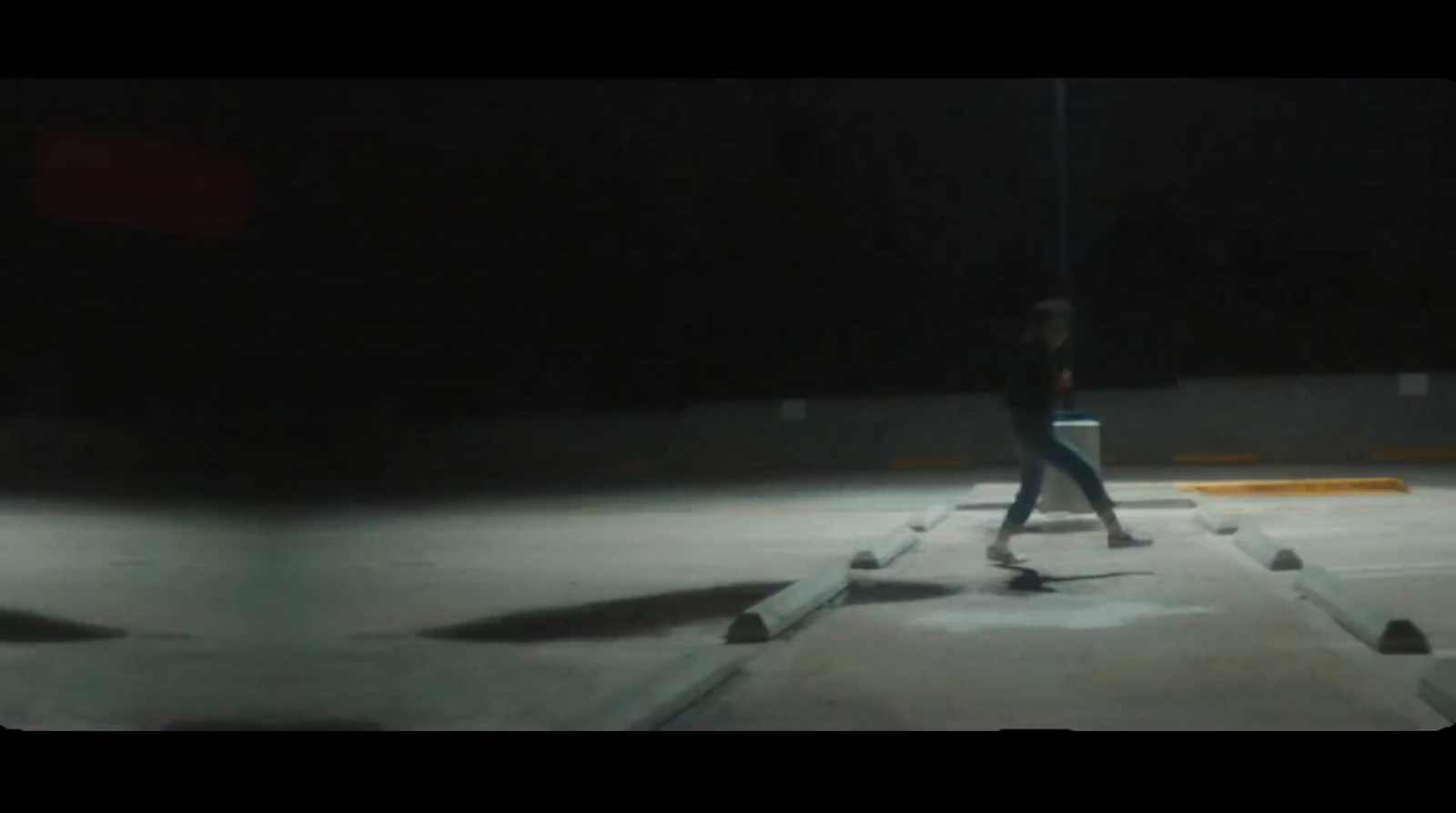 a man riding a skateboard across a parking lot