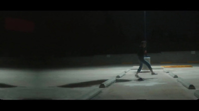 a man riding a skateboard across a parking lot