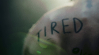 a close up of a person's shirt with the word tired written on it