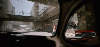 a rear view mirror of a car on a city street