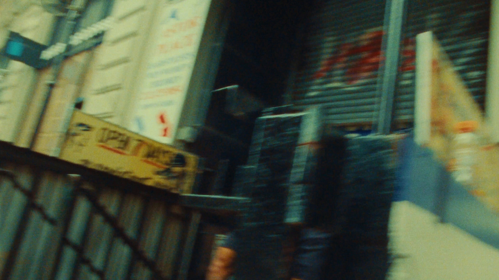 a man walking down a street past a tall building