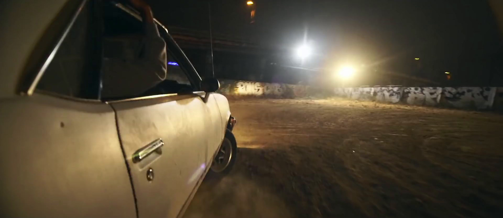 a car driving down a dirt road at night