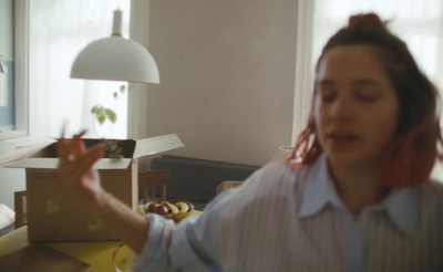 a woman in a blue shirt is holding a box