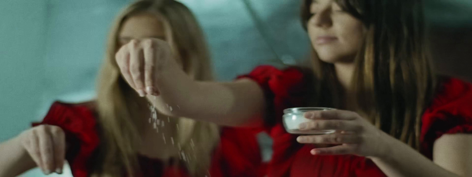 a woman in a red dress holding a glass of water