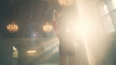 a woman standing in a room with a chandelier